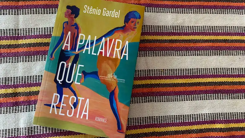 livro a palavra que resta em cima de tecido colorido amarelo e laranja